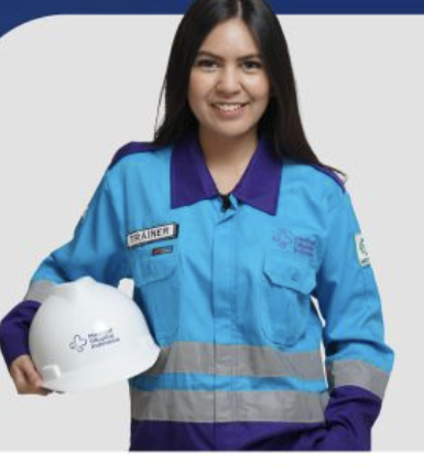 Trainer MEDIGAF mengenakan seragam kerja sambil memegang helm keselamatan